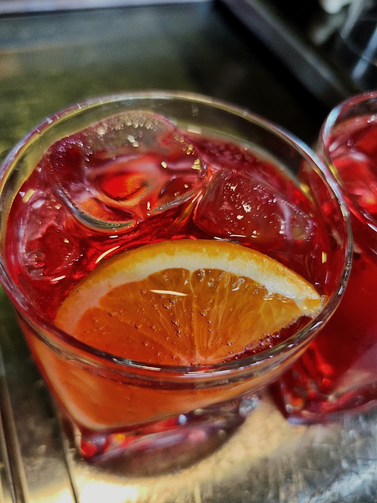 Bebida roja con hielo y naranja